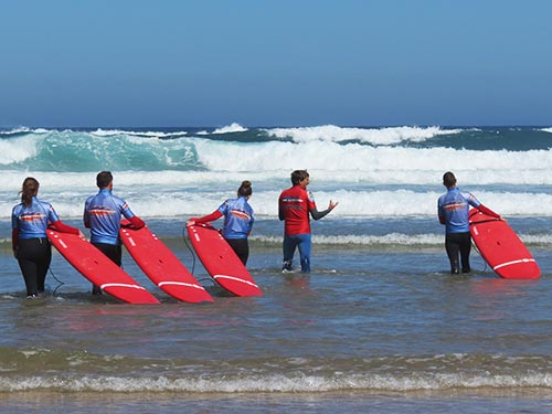 surfing group walkjing out into the waves