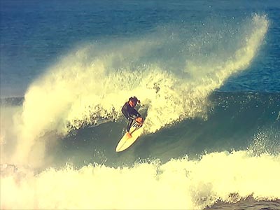 mike raven performing a top turn on a wave