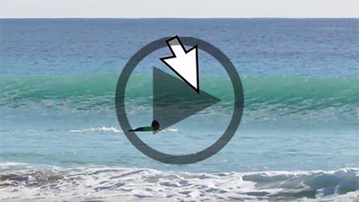 surfer paddling into a wave